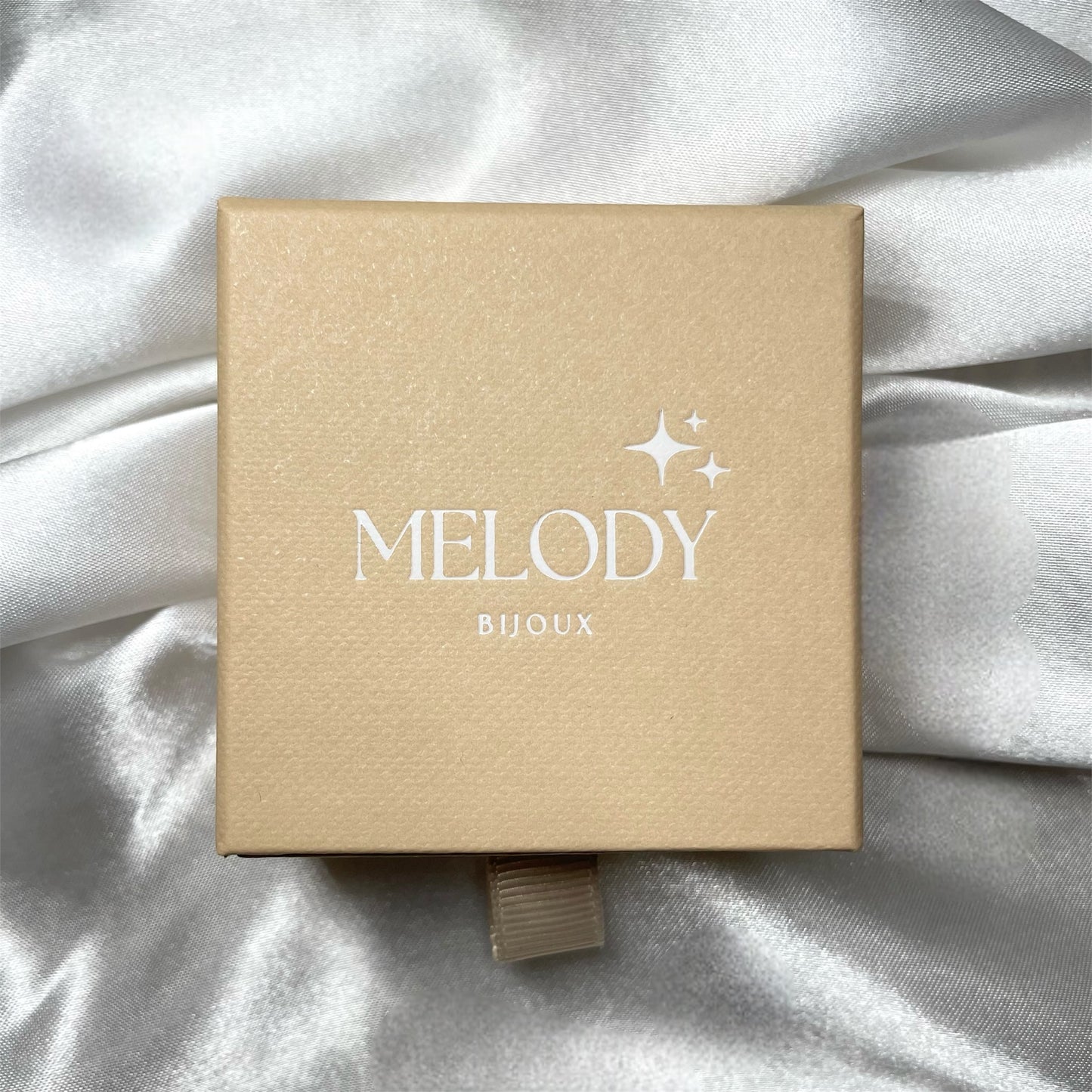 Écrin cadeau raffiné beige et blanc pour bijou en acier inoxydable doré ou argenté, idéal pour offrir un collier, bracelet, bague ou boucles d’oreilles lors d’une occasion spéciale.