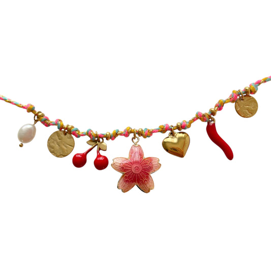 Bracelet coloré pour femme avec cordon textile et breloques fantaisie : perles, pastilles dorées, cerise rouge, piment porte-bonheur, cœur doré, et fleur rouge centrale. Un bijou bohème et estival, léger, ajustable et parfait pour les looks ensoleillés et décontractés.