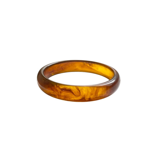 Bracelet jonc femme en résine marron au fini lisse et brillant. Léger et confortable, ce bijou tendance s’associe parfaitement avec un jonc doré en acier inoxydable pour un look raffiné. À porter seul ou en accumulation pour un style chic et minimaliste.