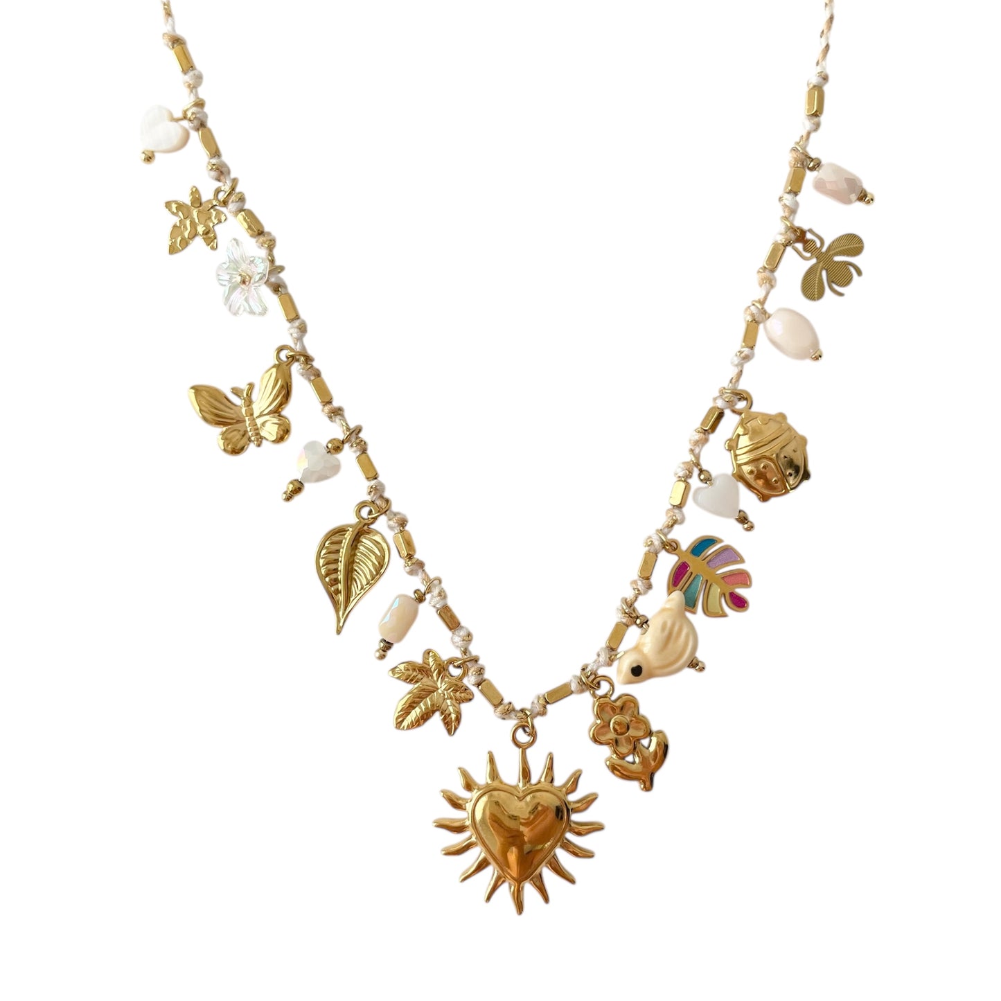 Collier femme tendance en cordon blanc avec breloques dorées en acier inoxydable : fleur, papillon, plume, cœur et palmier, accompagnés de perles blanches. Un bijou fantaisie chic, résistant à l’eau et hypoallergénique, parfait pour un style bohème lumineux en été.
