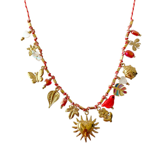 Collier femme estival en cordon rouge orné de breloques dorées en acier inoxydable : fleur, papillon, palmier, cœur, plume et perles multicolores. Bijou fantaisie tendance, résistant à l’eau et à l’oxydation, idéal pour un look bohème chic sous le soleil.